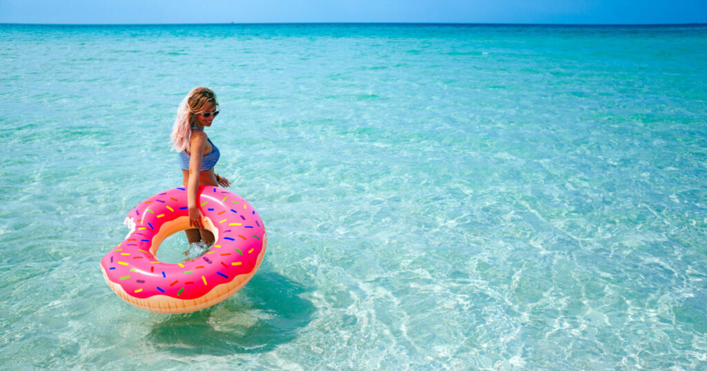 Woman in sea with inflatable doughnut