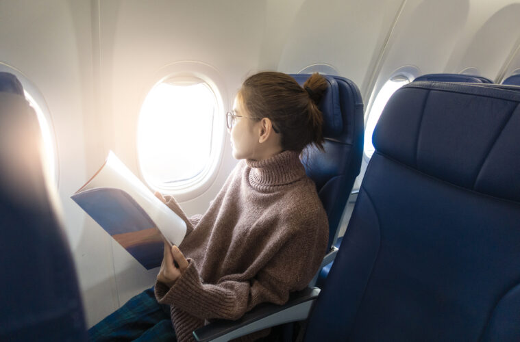 Woman reading magazine on plane