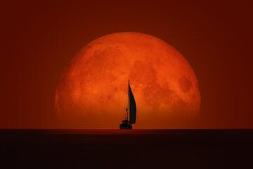 Yacht against a red moon