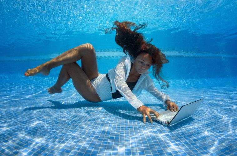 Woman underwater with laptop