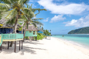 View along Lalomanu Beach, Upolu Island, Samoa, South Pacific, of colorful Samoan beach fale huts that are an alternative to hotel or resort accommodation