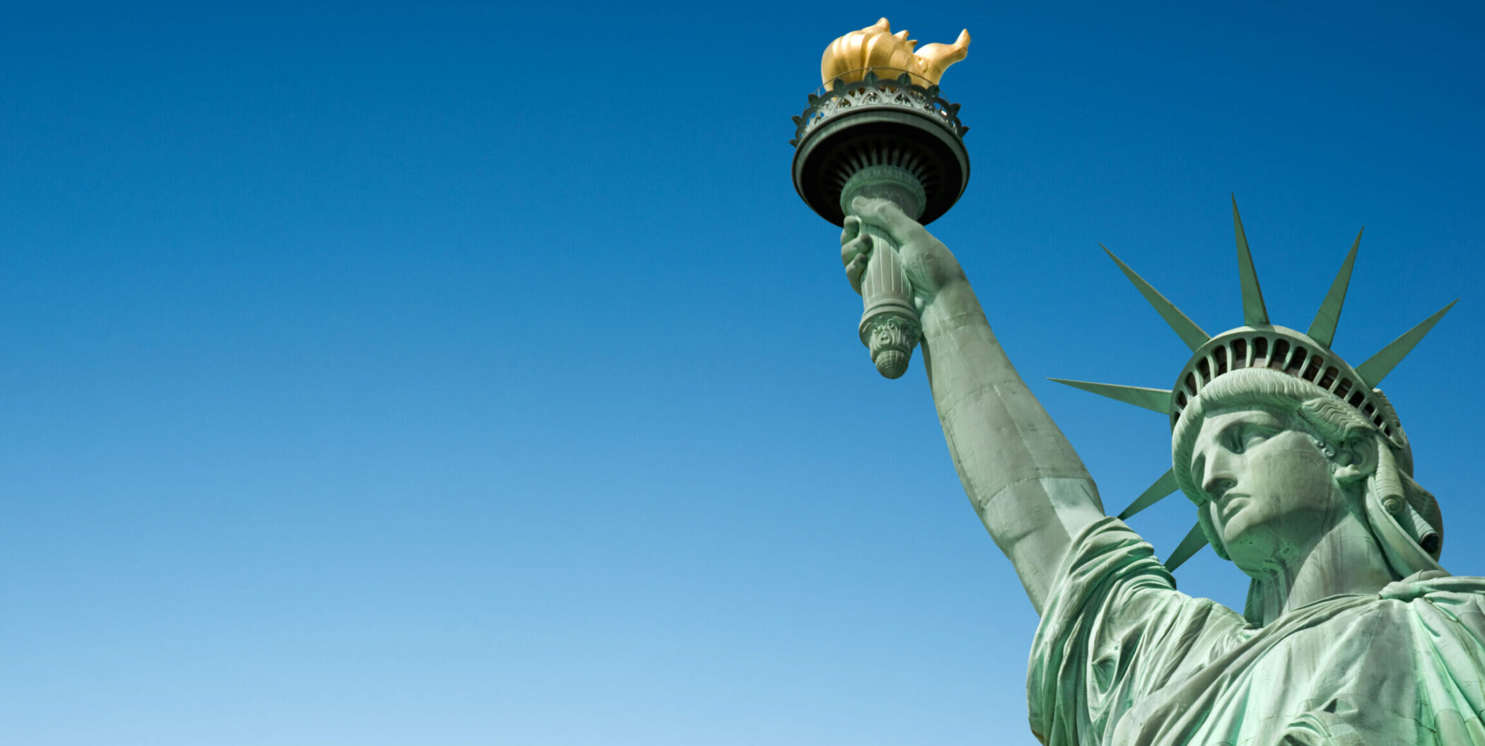 Close up of the Statue of Liberty in New York, USA. Blue sky background with copy space
