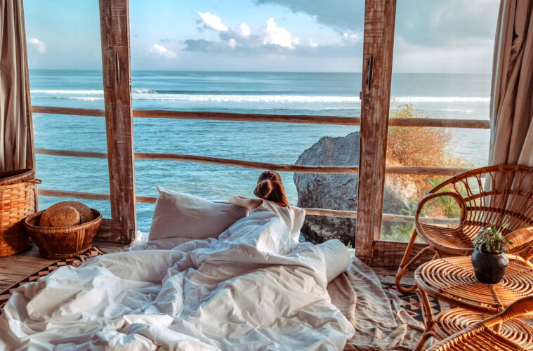 Woman enjoying morning vacations on tropical beach bungalow looking ocean view Relaxing holiday at Uluwatu Bali ,Indonesia
