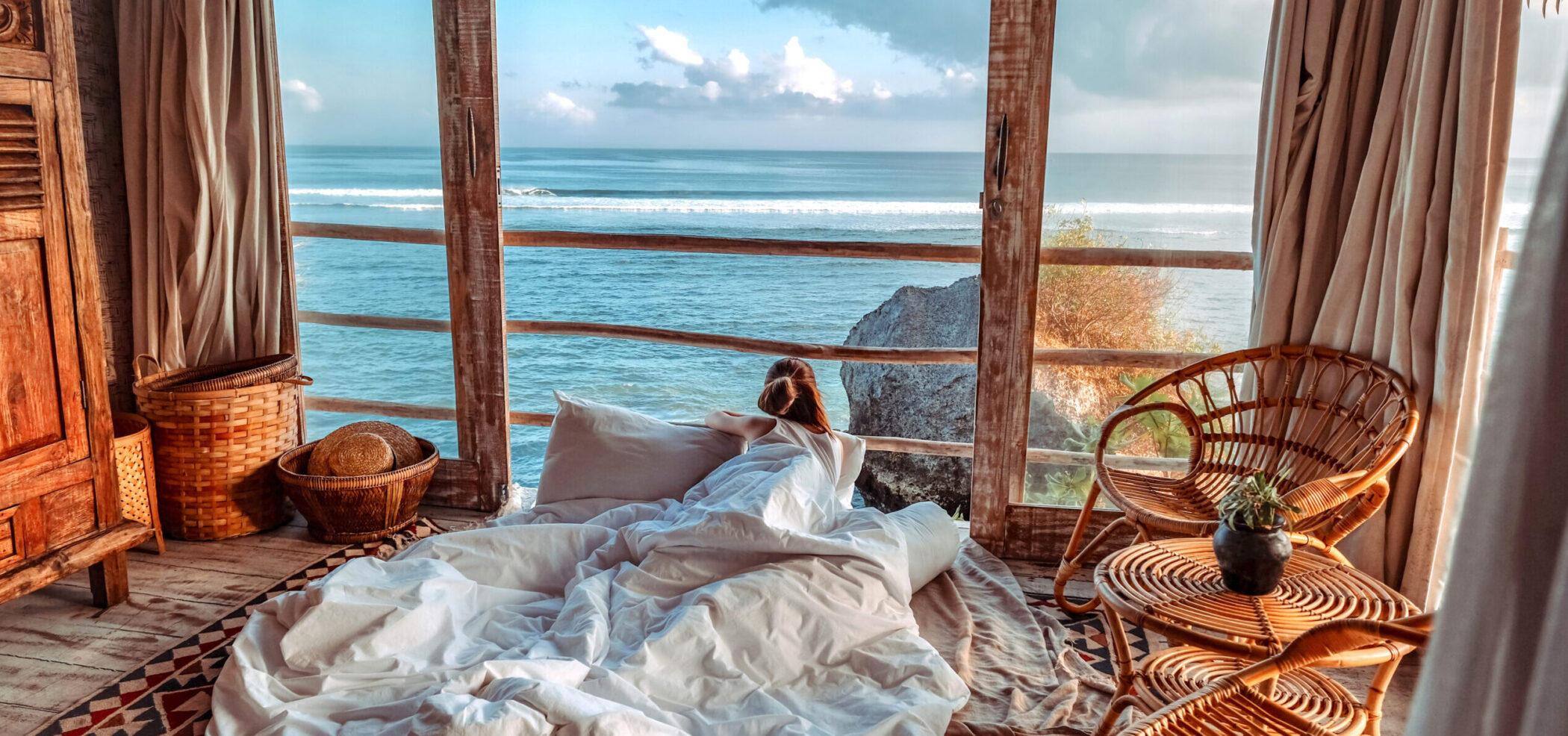 Woman enjoying morning vacations on tropical beach bungalow looking ocean view Relaxing holiday at Uluwatu Bali ,Indonesia