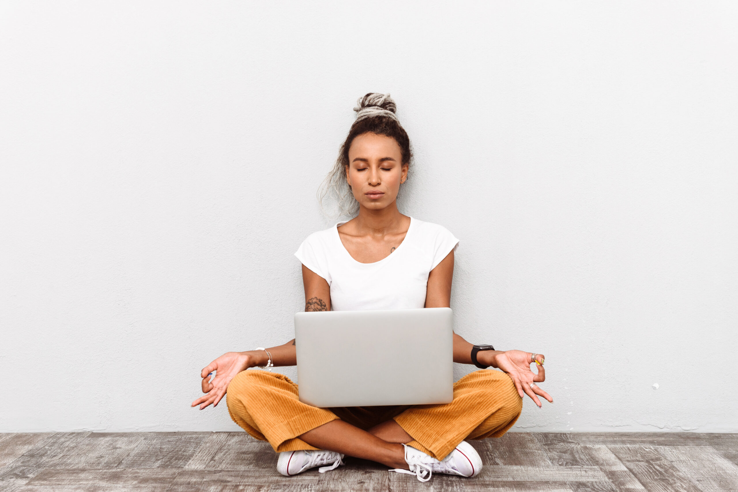 Woman meditating with laptop