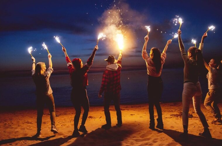 Friends on beach with flares