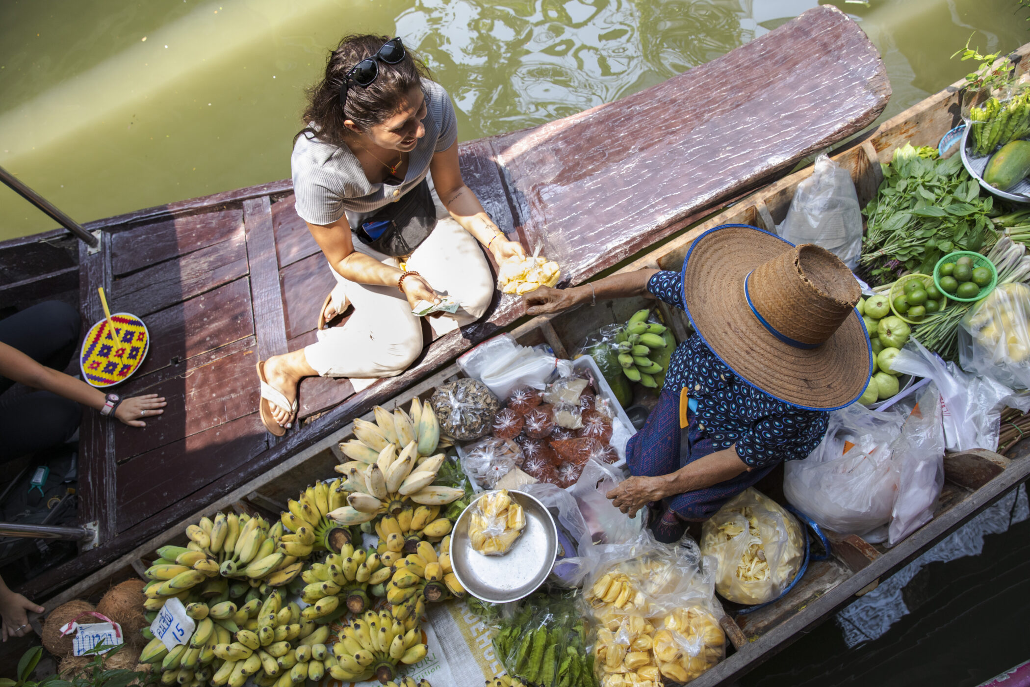 Thailand Bangkok Floating Market Boat Tour Female Traveller Local Woman Interaction Buying Fruit