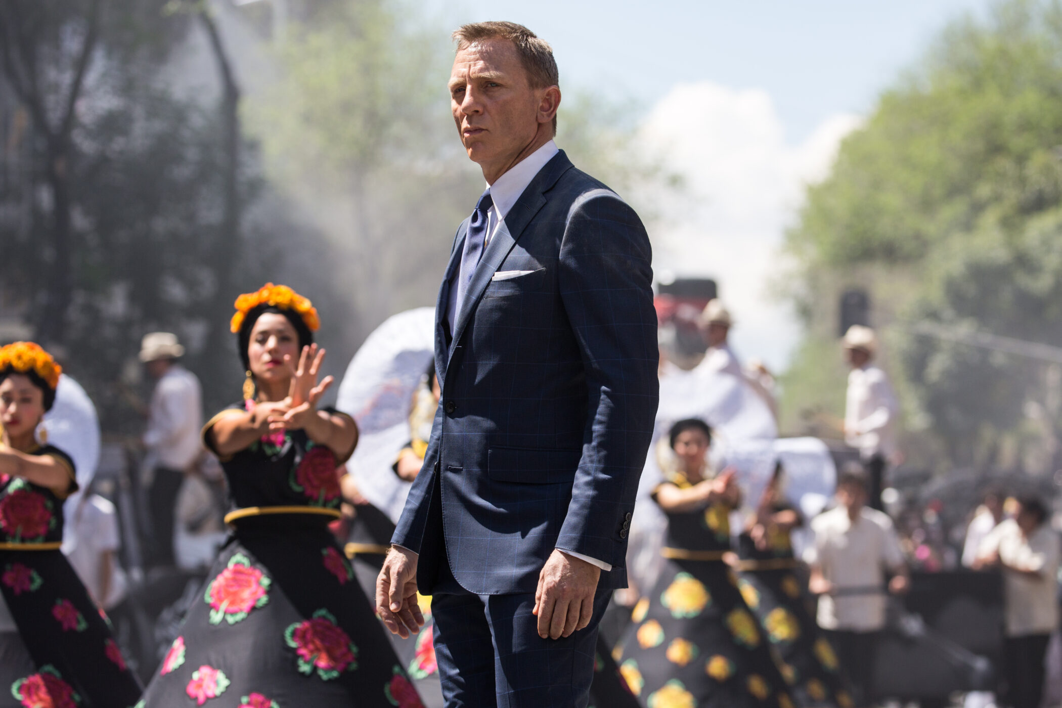 Bond (Daniel Craig) following Marco Sciarra through the Day of the Dead parade; Tolsa Square, Mexico City.